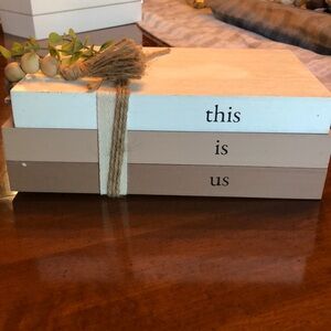 Wooden fake book stack with “this is us”